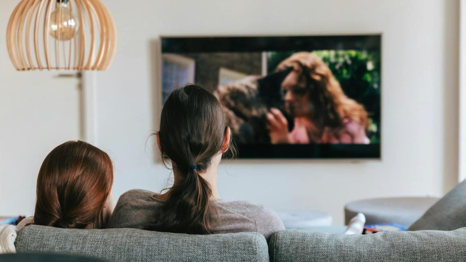 Twee mensen op de bank kijken naar een videopodcast op televisie